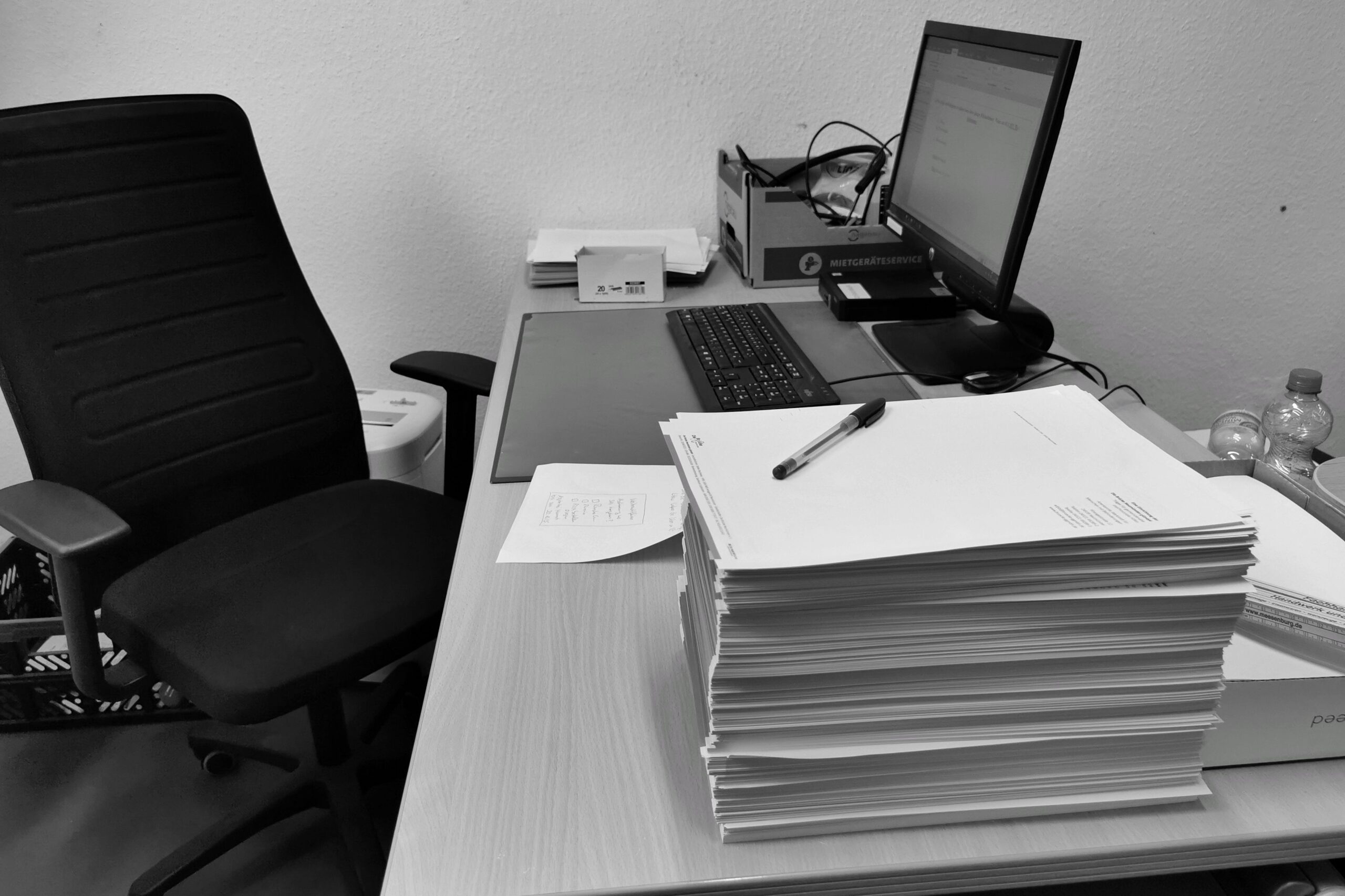 Pila de documentos y papeleo sobre un escritorio de oficina