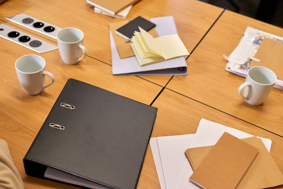Carpeta y documentos sobre una mesa de trabajo