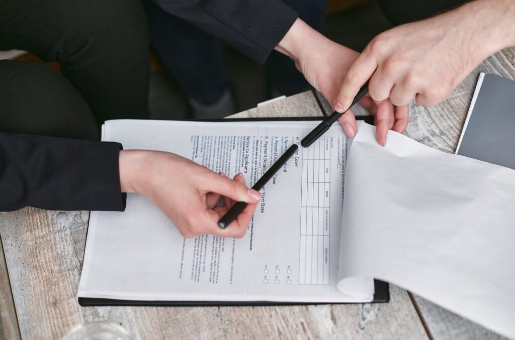 Manos revisando un documento con bolígrafo